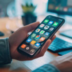 Il ragazzo lavora al computer e al telefono