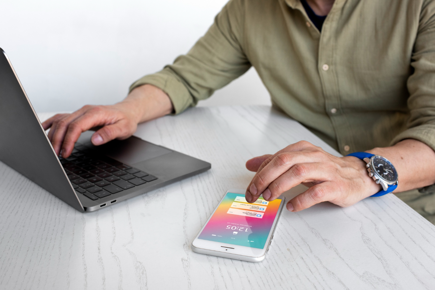 un uomo usa uno smartphone e un laptop