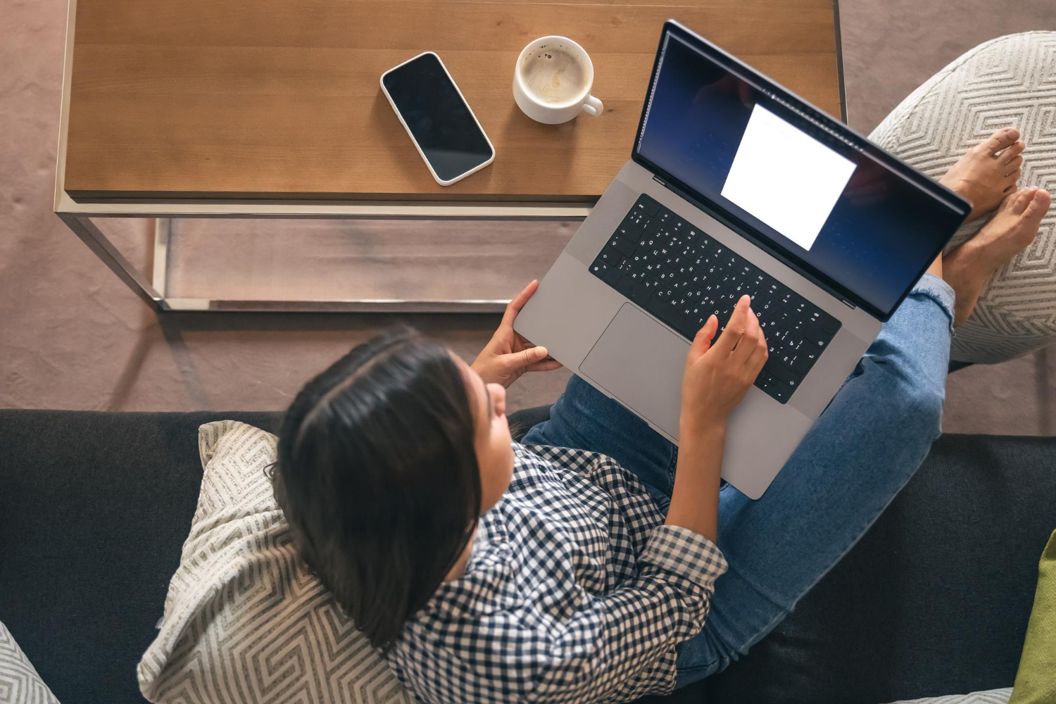 Una ragazza è seduta su un divano con un computer portatile